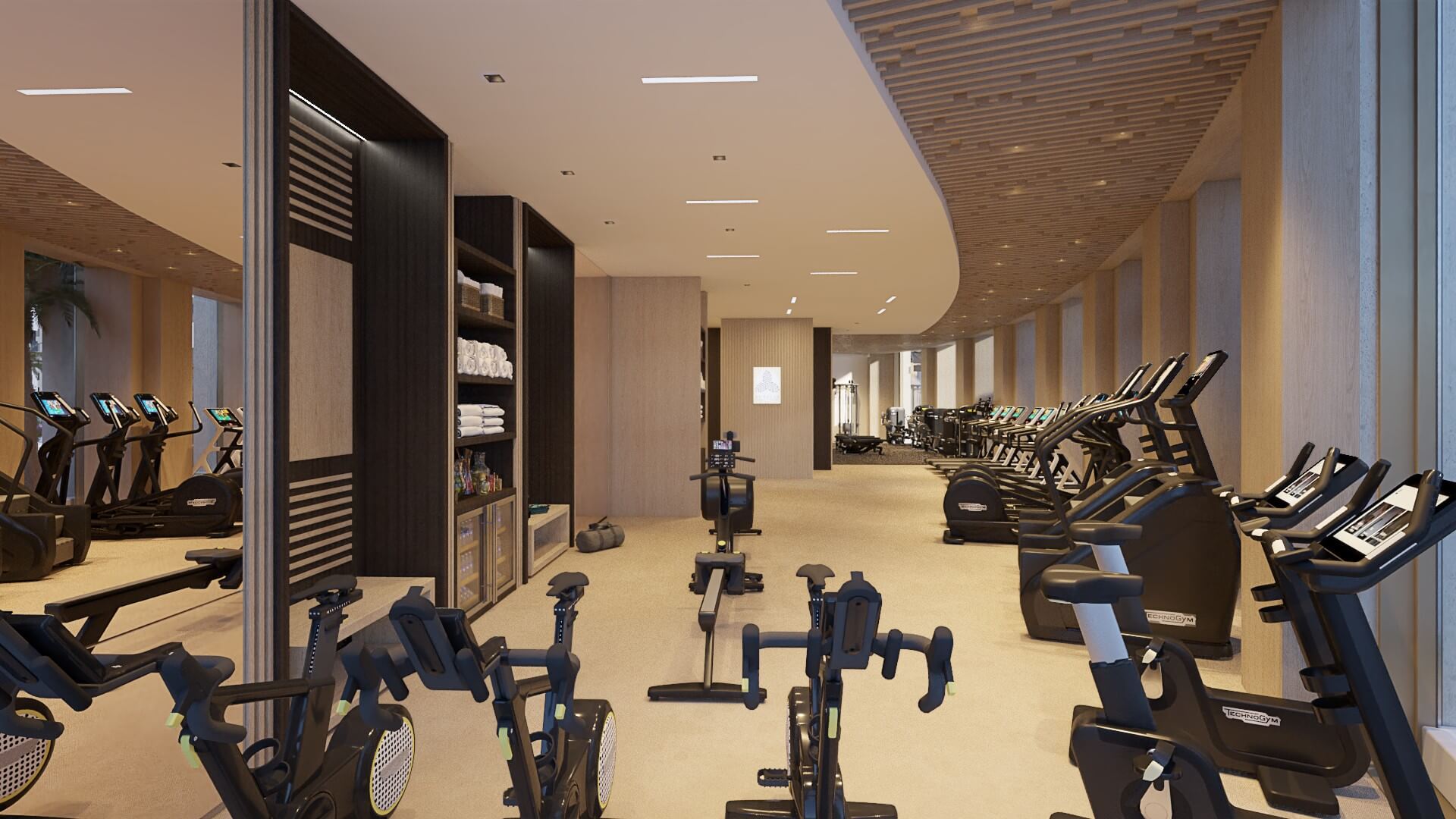 Interior view of a modern, spacious fitness center equipped with rows of stationary bikes and strength training machines under warm, recessed lighting.