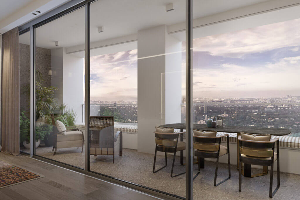 Spacious signature balcony featuring outdoor dining set and glass railings with panoramic city views.