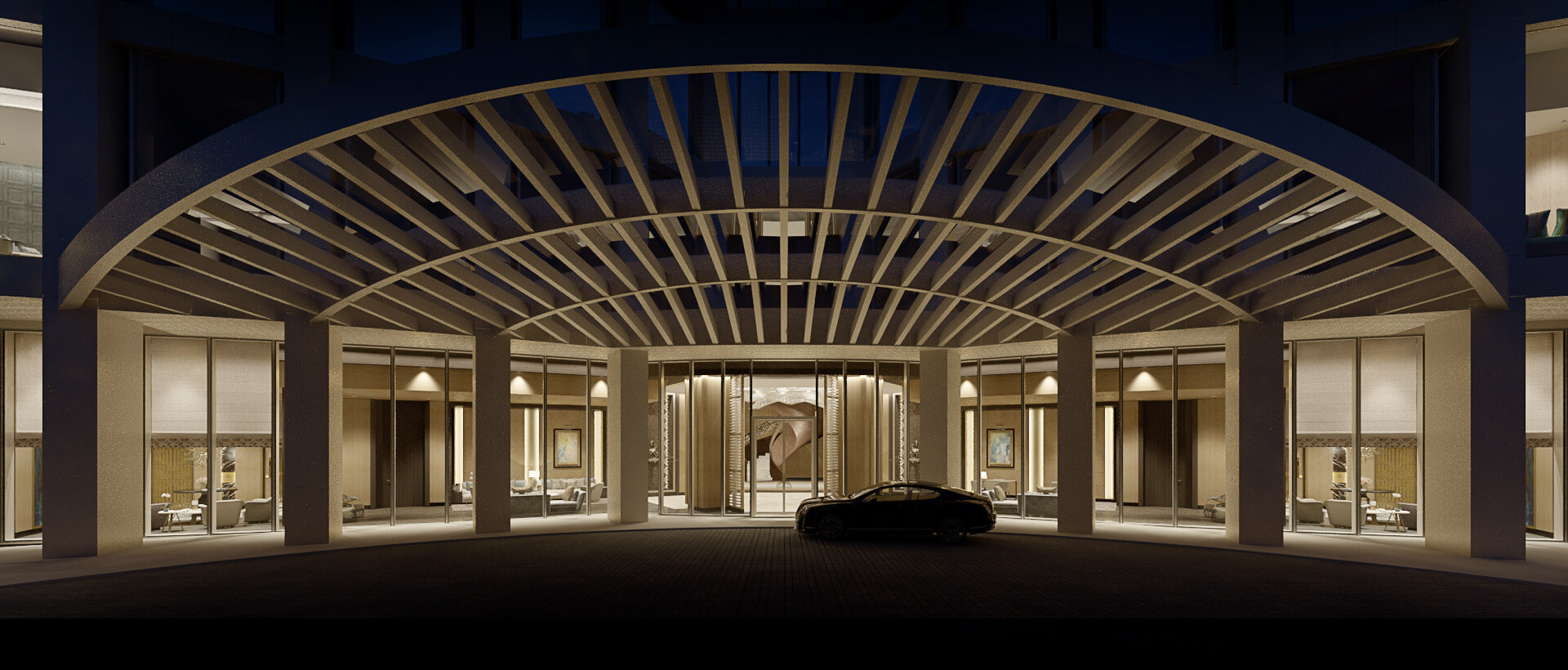 A dramatic night view of a luxury building drop-off area featuring a circular white pergola structure and warm architectural lighting.