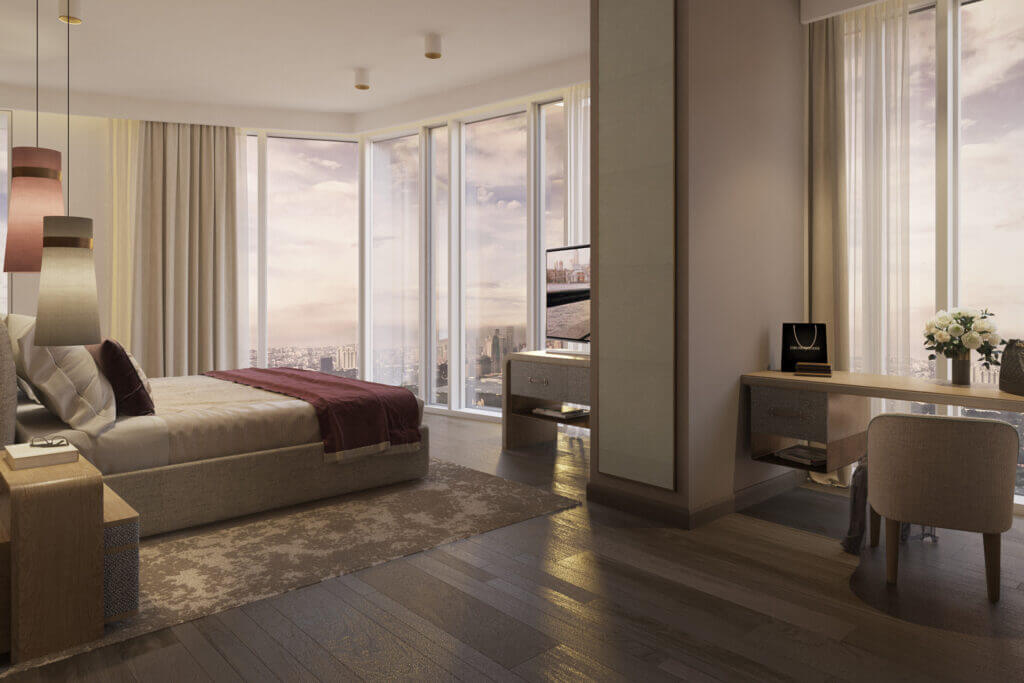 Luxury high-rise bedroom featuring floor-to-ceiling windows, neutral-toned bed with burgundy throw, and dedicated vanity workspace with urban sunset views.