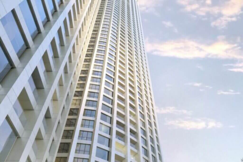 Exterior perspective of a modern white high-rise tower with a grid-like window pattern reaching toward the sky.